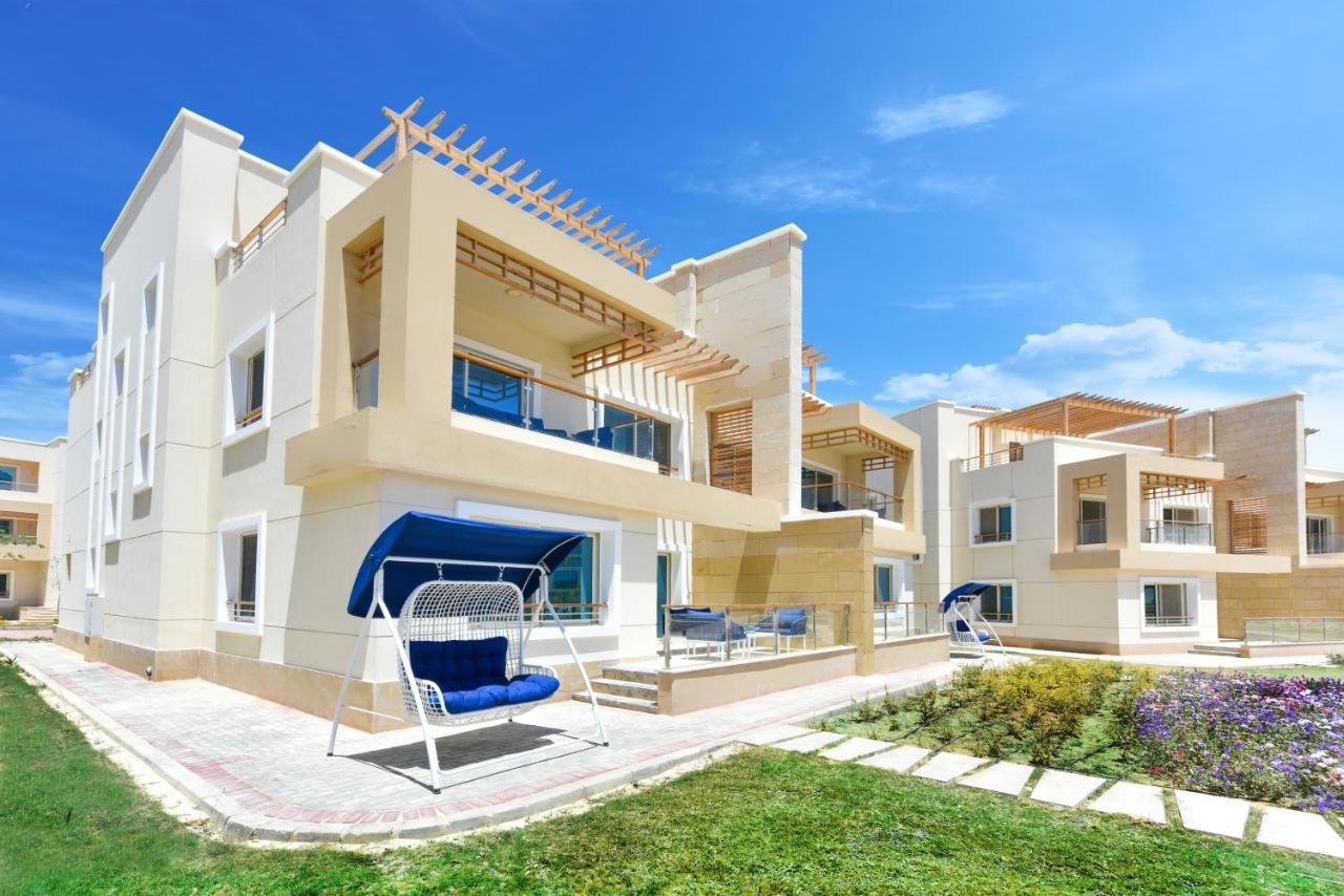 Tolip Resort El Galala Majestic Ain Sukhna Buitenkant foto The photo displays a modern residential complex featuring two or more white buildings with a contemporary architectural design. Each building has balconies, large windows, and a sunshine-friendly layout that maximizes natural light. In the foreground